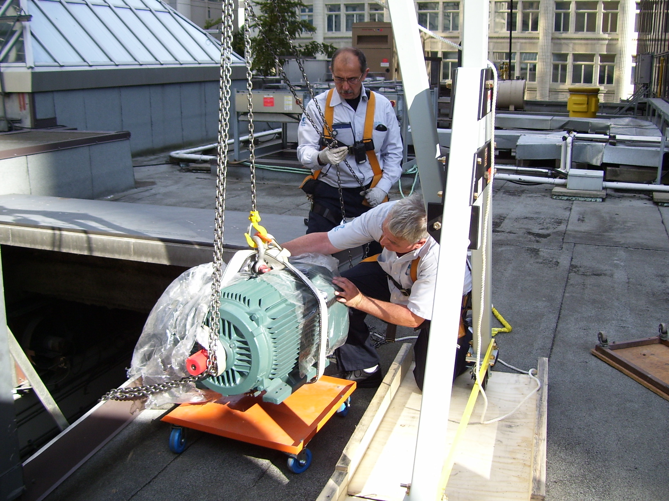 eme aluminum gantry crane helping operators replace a blower on a rooftop